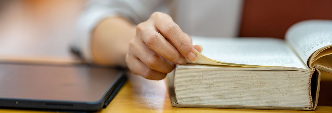 Eine Frau  liest in einem Lexikom