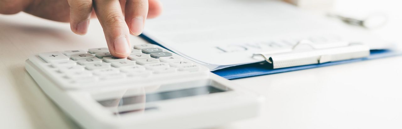 Ein Mann berechnet mit einem Taschenrechner Zahlen einer Liste Ein Mann berechnet mit einem Taschenrechner Zahlen einer Liste