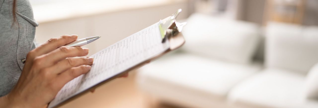 Eine Frau &uuml;berpr&uuml;ft an Hand einer Liste...