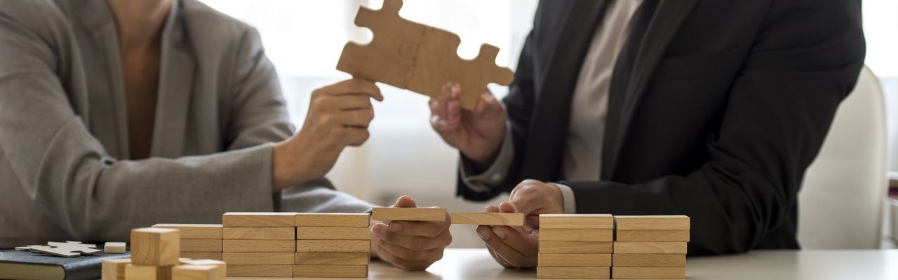 zwei Personen verbinden sich durch passende Puzzlestücke